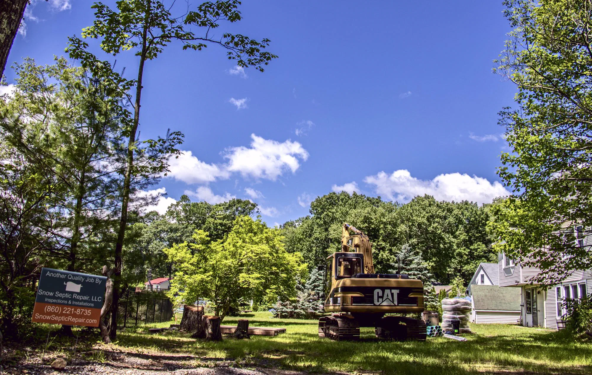 CAT excavator on a residential job site under a blue sky